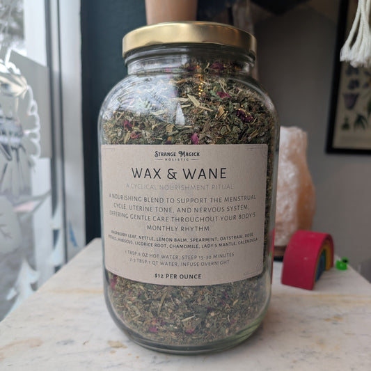 Glass jar with a label on a surface, containing custom tea blend