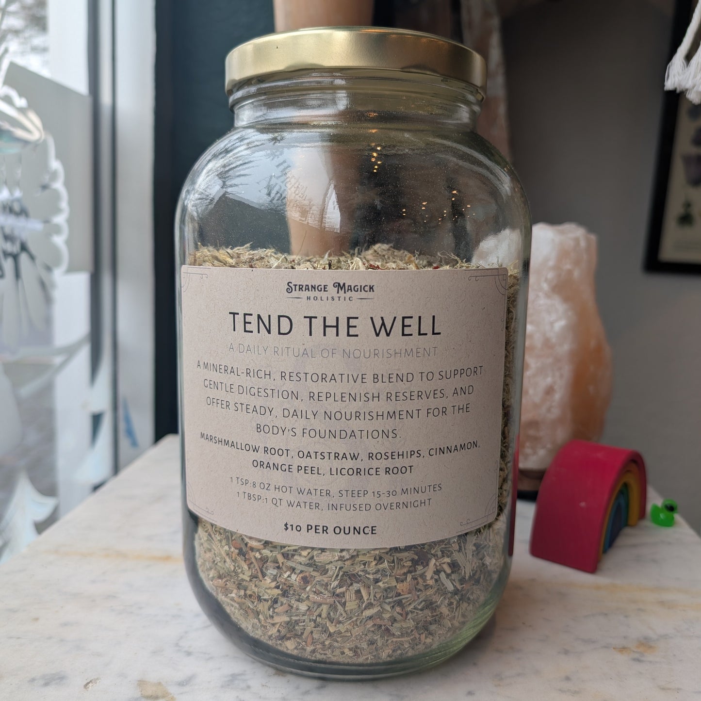 Glass jar labeled 'Tend the Well' filled with custom tea blend