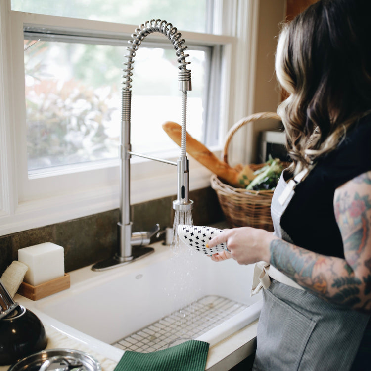 woman washing dishes with reusable dish cloth from zero waste store Kindred Vancouver WA