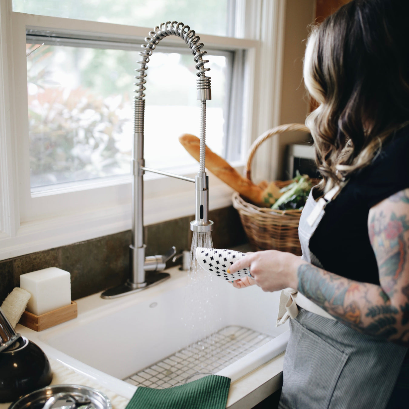 woman washing dishes with reusable dish cloth from zero waste store Kindred Vancouver WA