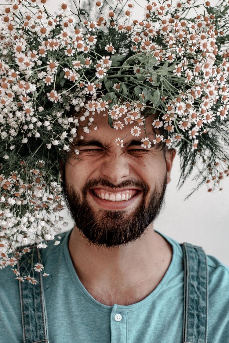 phot of man with daisies on his head for kindred vancouver zero waste shop