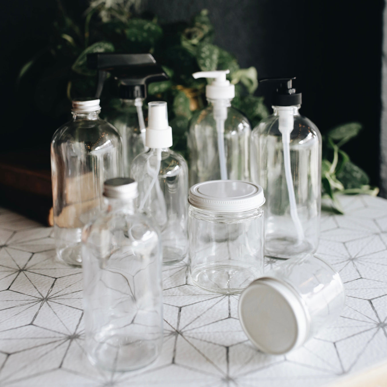 group of glass containers, spray bottles, dropper bottles and canisters