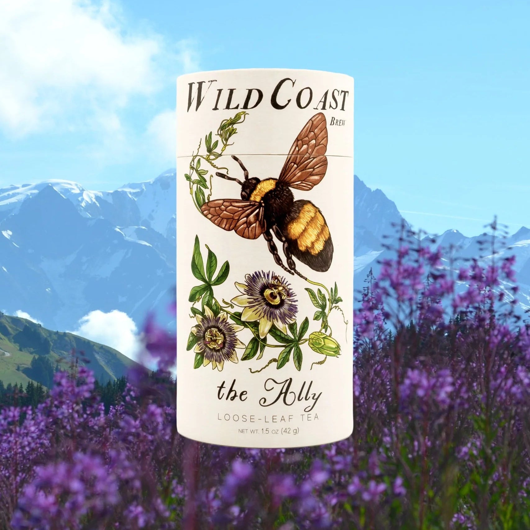 Wild Coast Tea packaging with a bee illustration against a mountain and lavender background