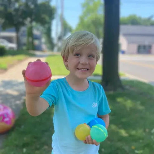Boy holding reusable water balloons - shop plastic free on Kindred Vancouver