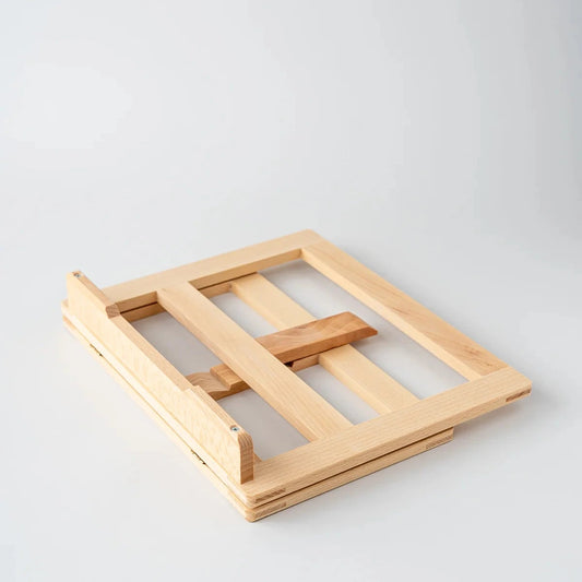 Folded wooden book holder on a light gray background