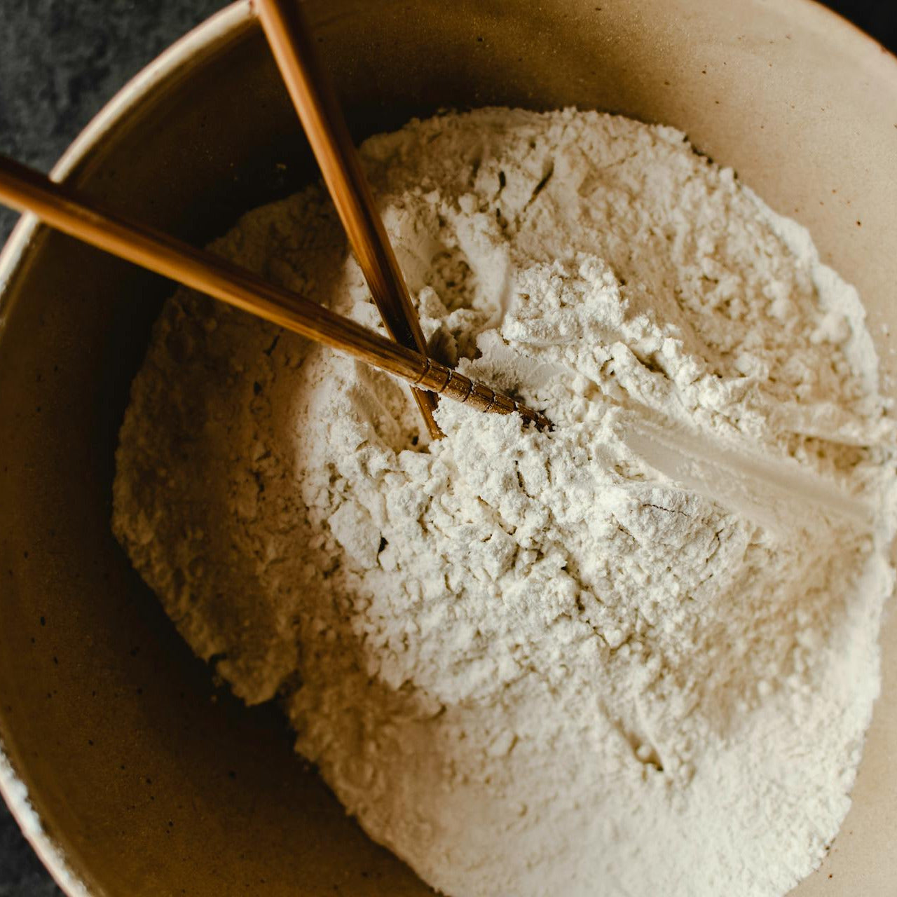 Bowl of powder with a spoon on a dark background