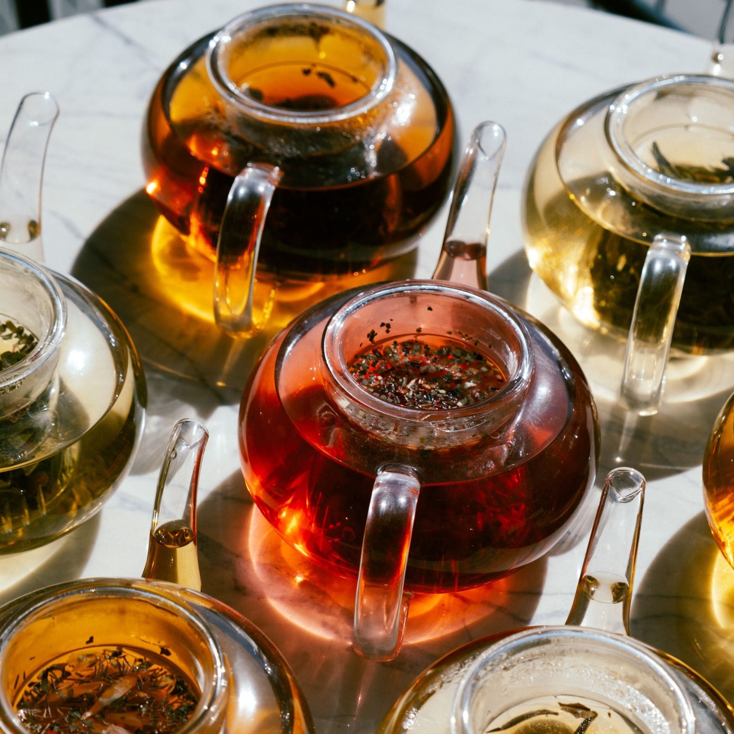 A variety of tea pots filled with loose leagf tea