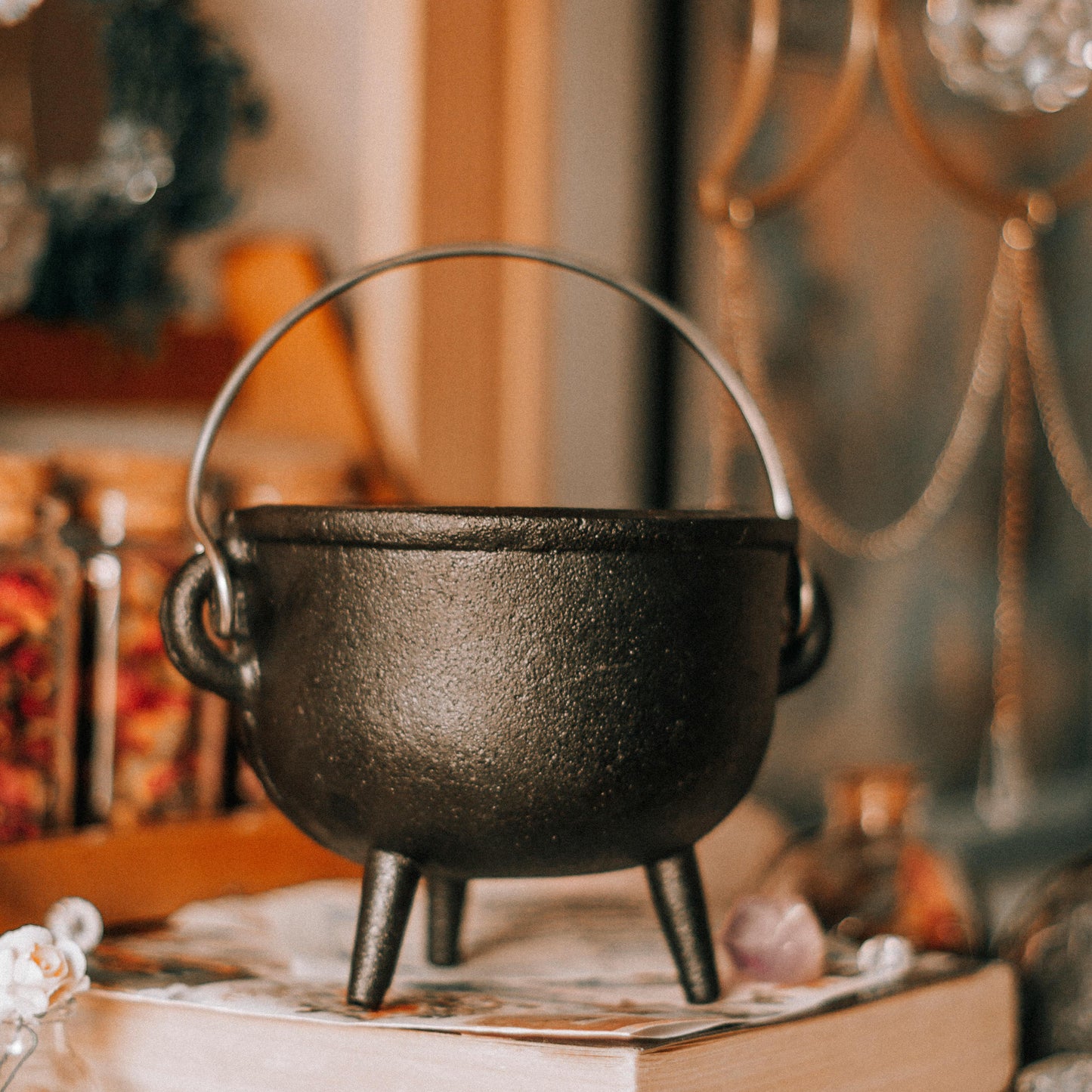 Black cast iron cauldron on books with a blurred background