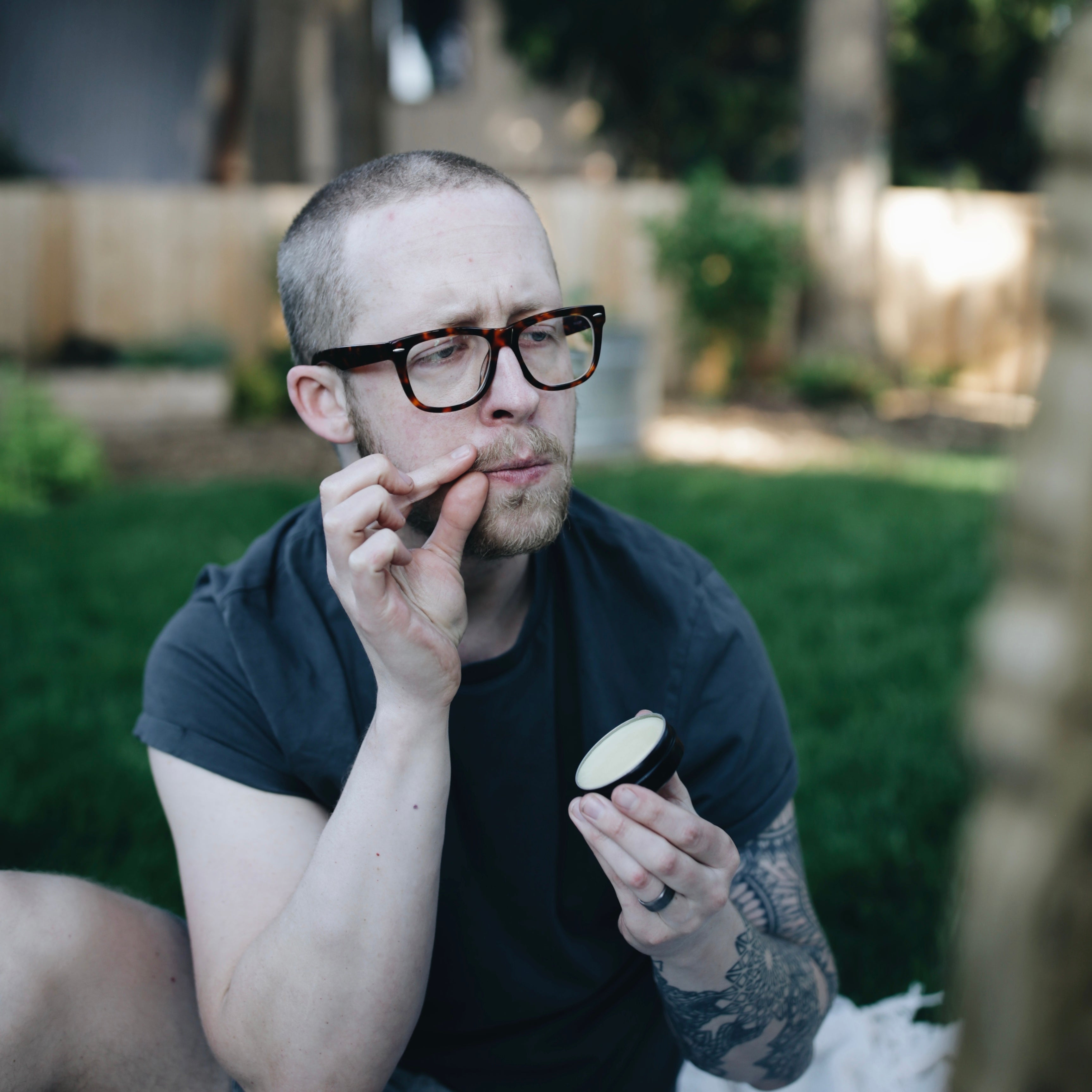 man applying beard balm to mustache